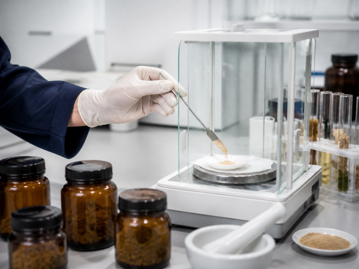 Botanical powder sample weighed on an analytical balance in a QC laboratory for bulk ingredient COA testing